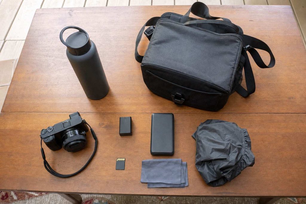 An outdoor photography day kit laid out flat on a wooden table